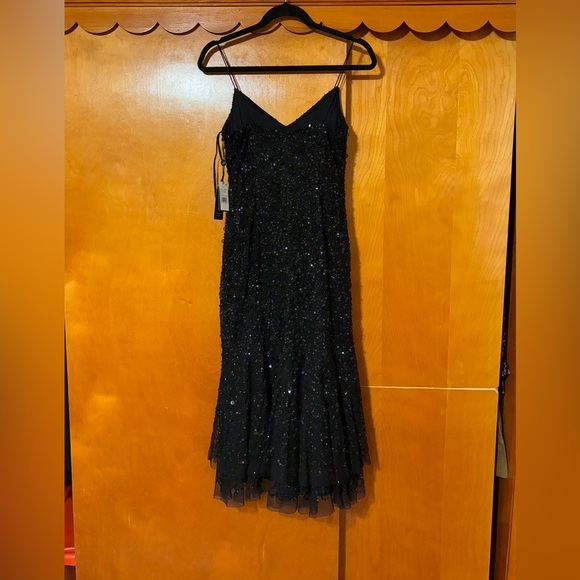 Shiny sequins and a sheer asymmetrical hem accentuate this sleeveless dress - Picture 3 of 6